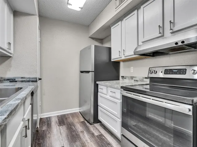 a kitchen with stainless steel appliances granite countertop a stove and a refrigerator