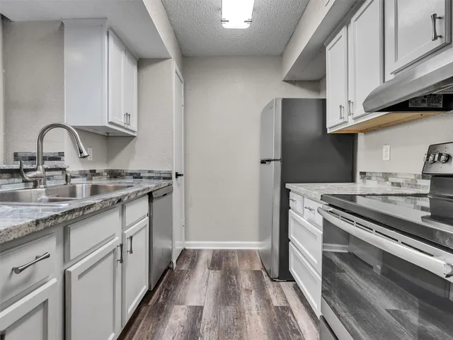 a kitchen with granite countertop stainless steel appliances and wooden cabinets