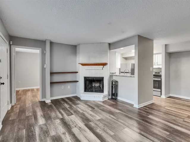 a view of a livingroom with a fireplace a ceiling fan and window