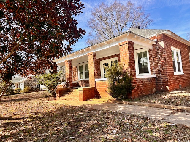 This brick residence features a welcoming porch, perfect for outdoor enjoyment.