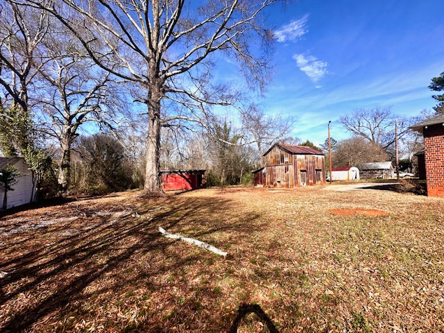 1208 West Whitner Street Anderson, SC 29625 - Photo 4 of 23 This spacious yard offers ample outdoor potential, complete with mature trees and rustic outbuildings.