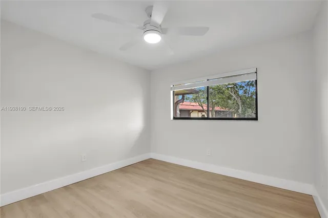 an empty room with a window and wooden floor