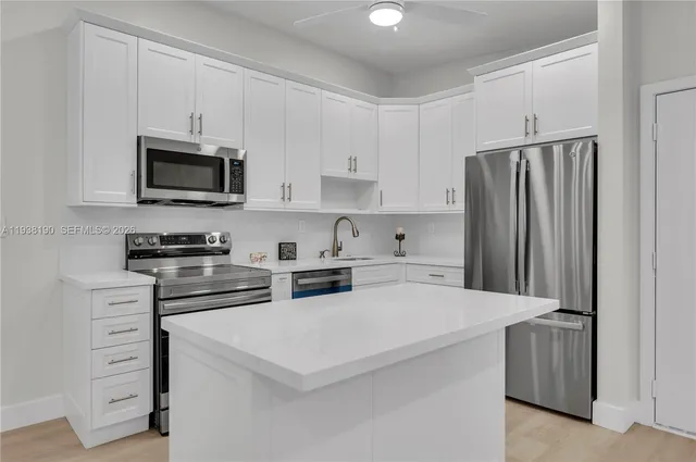 a kitchen with stainless steel appliances a stove microwave and sink