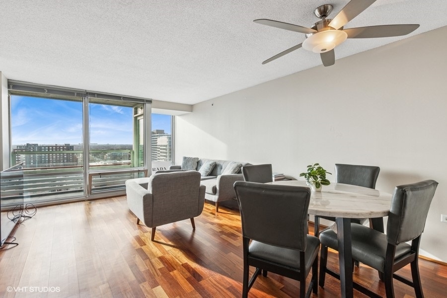 800 Elgin Road, Unit 1502 Evanston, IL 60201 - Photo 2 of 19 a dining room with furniture a flat screen tv and a large window