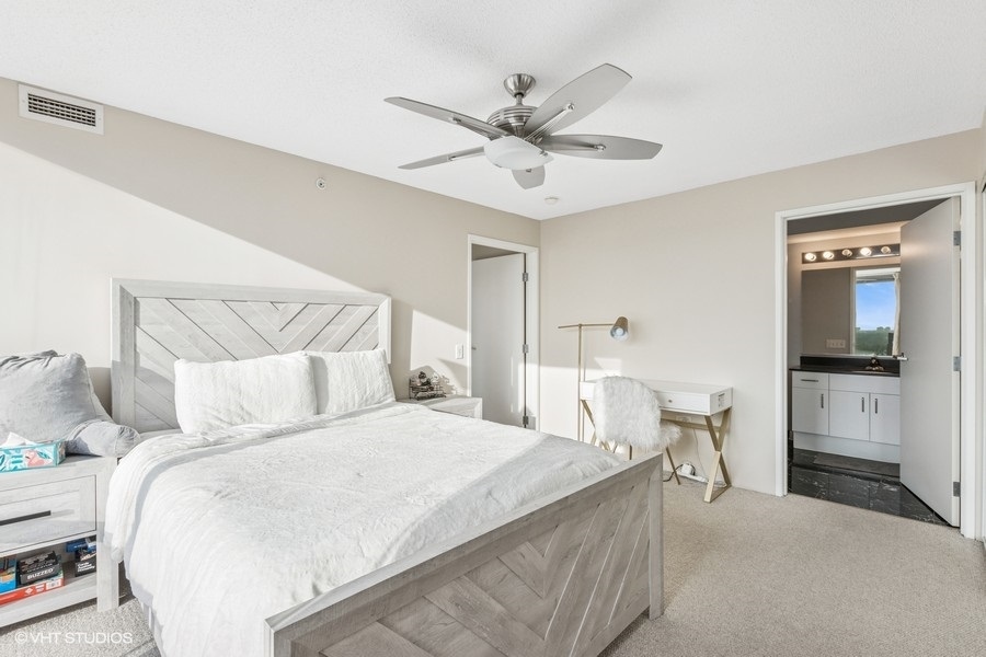 800 Elgin Road, Unit 1502 Evanston, IL 60201 - Photo 9 of 19 a bedroom with a bed and a chandelier