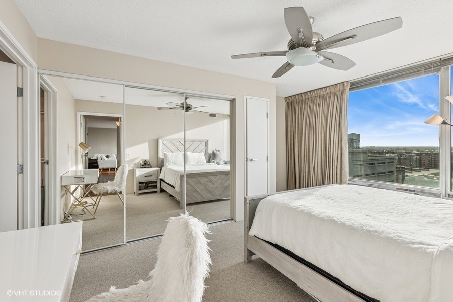 800 Elgin Road, Unit 1502 Evanston, IL 60201 - Photo 10 of 19 a bedroom with a bed mirror and furniture