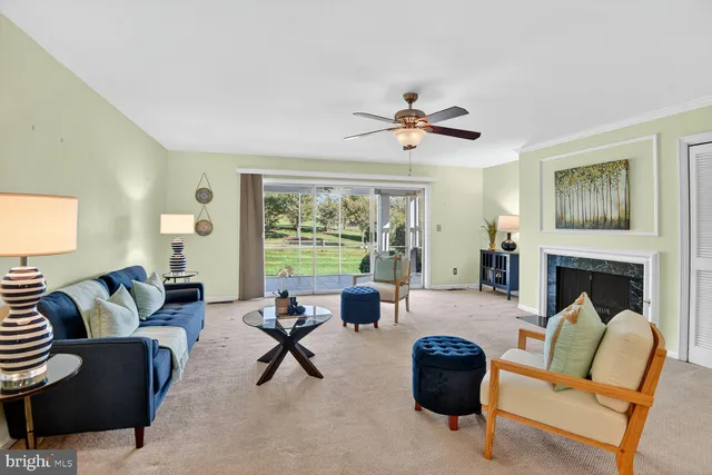 a living room with furniture fireplace and a large window