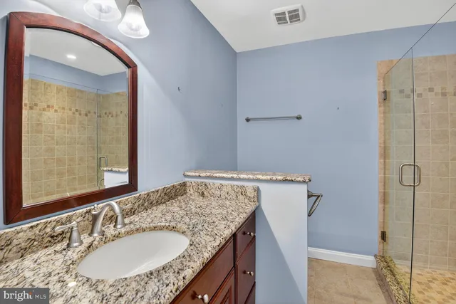 a bathroom with a granite countertop sink and a mirror