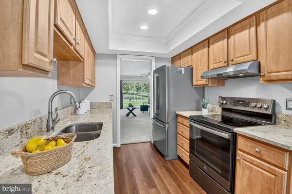 a kitchen with stainless steel appliances granite countertop a stove a sink and a refrigerator