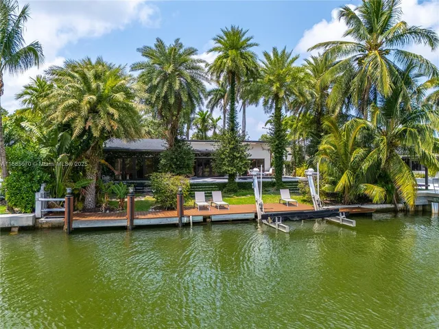 a view of an house with swimming pool and chairs