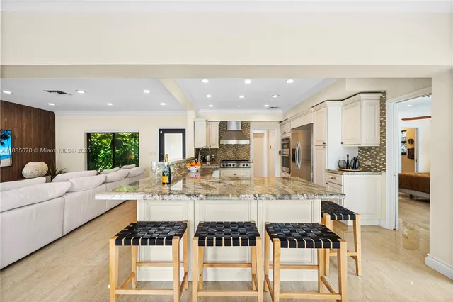 a kitchen with a dining table chairs stove and white cabinets
