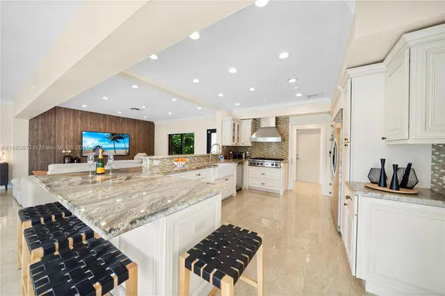 a kitchen with stainless steel appliances kitchen island granite countertop a refrigerator and a stove top oven