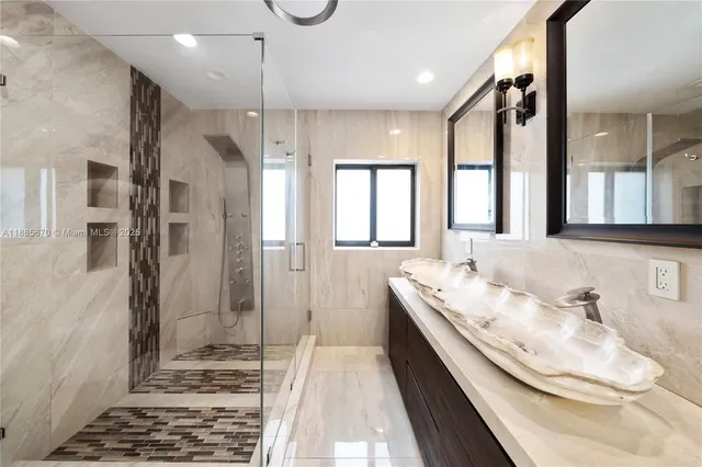a bathroom with a double vanity sink mirror and shower