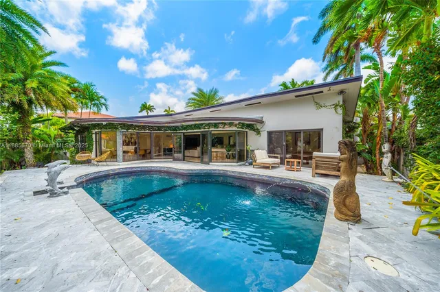 a view of a house with swimming pool and sitting area