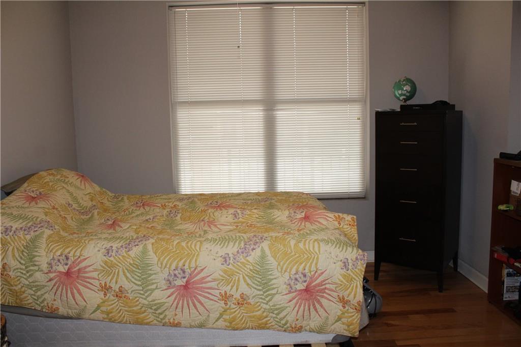 1101 Juniper Street Northeast, Unit 1416 Atlanta, GA 30309 - Photo 14 of 48 a bedroom with a bed and wooden floor