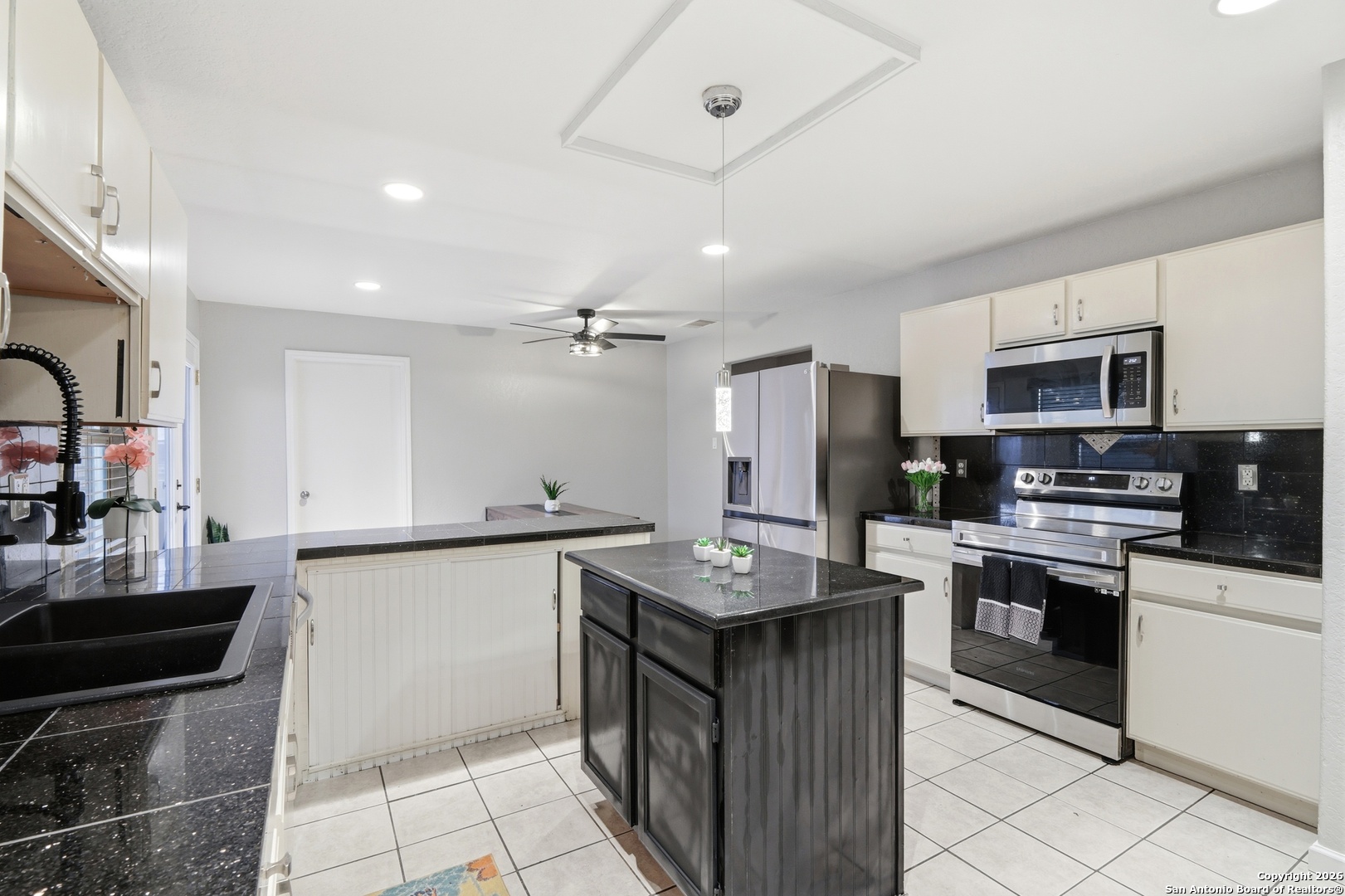 814 Inks Farm San Antonio, TX 78228 - Photo 13 of 32 a kitchen with stainless steel appliances granite countertop a sink a stove top oven a counter space and cabinets