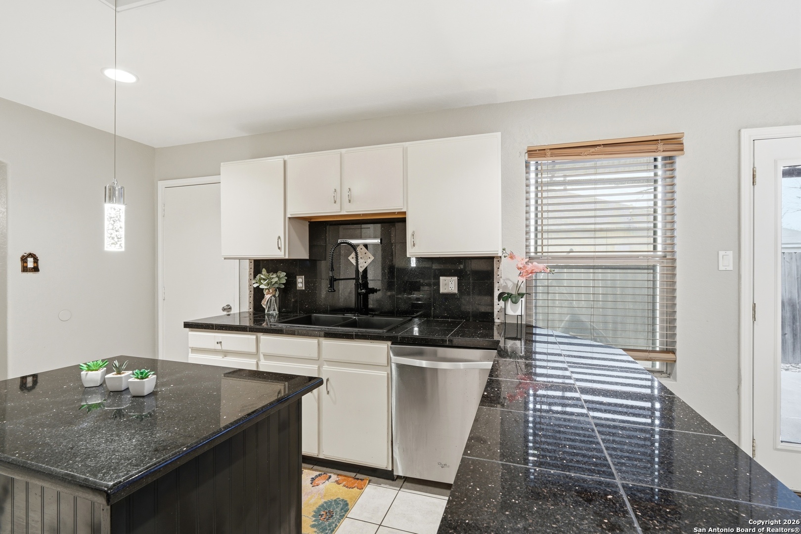 814 Inks Farm San Antonio, TX 78228 - Photo 15 of 32 a kitchen with granite countertop a sink and white cabinets