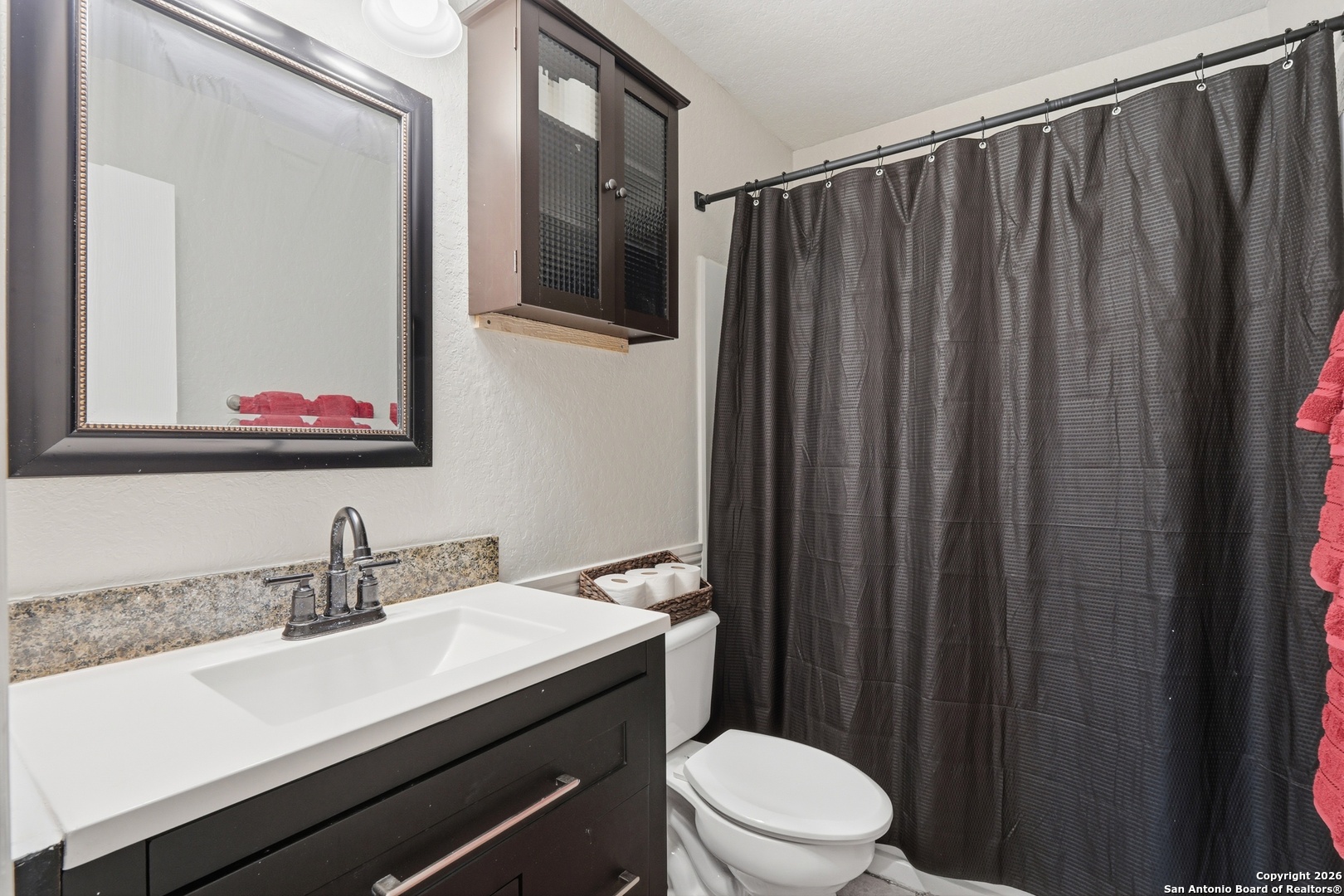 814 Inks Farm San Antonio, TX 78228 - Photo 21 of 32 a bathroom with a sink a toilet a mirror and shower curtain