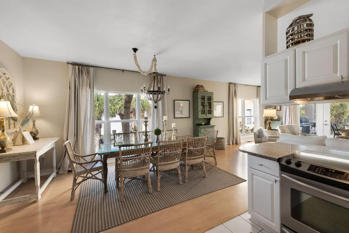 4192 East County Highway 30A, Unit A Santa Rosa Beach, FL 32459 - Photo 4 of 30 a kitchen with stainless steel appliances granite countertop a stove a refrigerator a kitchen island a dining table and chairs with wooden floor