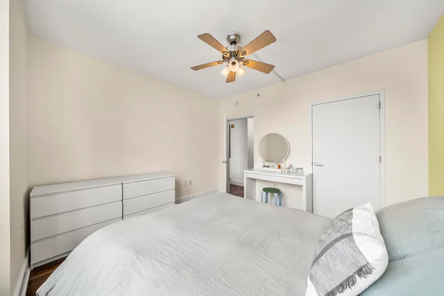 a bedroom with a bed and a ceiling fan