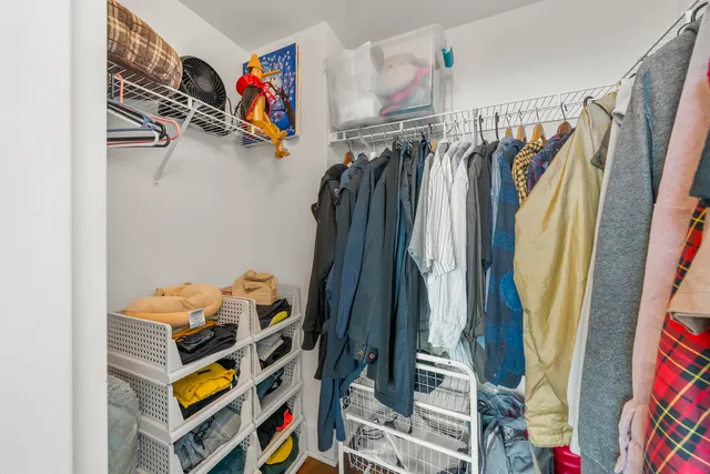 a view of walk in closet with clothes and shoes