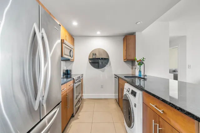 a kitchen with stainless steel appliances granite countertop a refrigerator and a sink