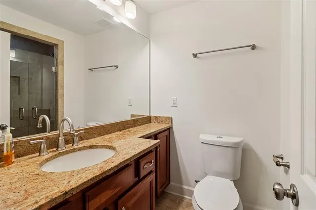 a bathroom with a granite countertop toilet sink and mirror