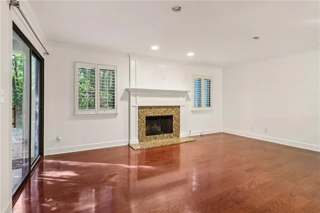 an empty room with windows and fireplace
