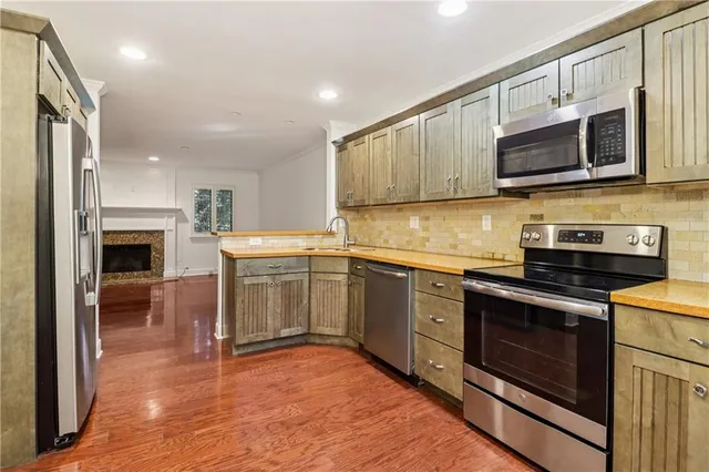 a kitchen with stainless steel appliances granite countertop a stove top oven a sink and a microwave