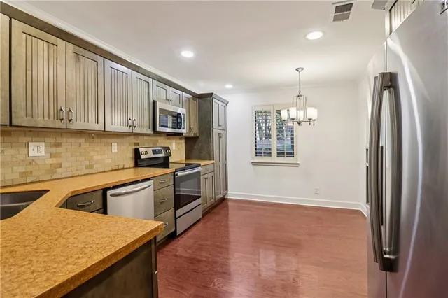 a kitchen with stainless steel appliances granite countertop a refrigerator a sink and a stove