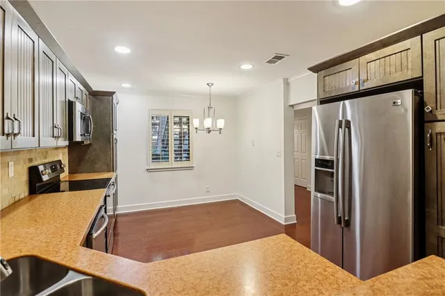a kitchen with stainless steel appliances granite countertop a refrigerator and a sink