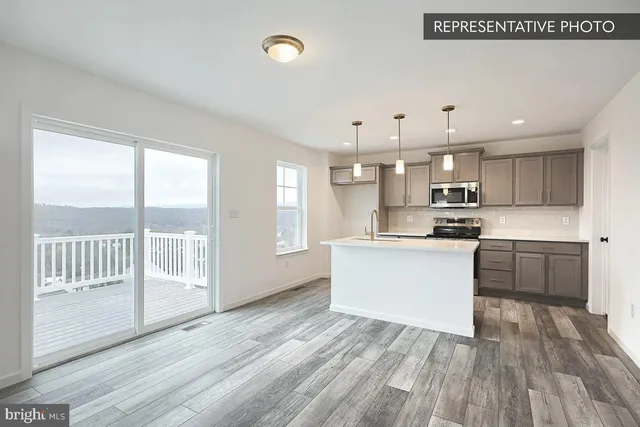 a view of kitchen with wooden floor and electronic appliances