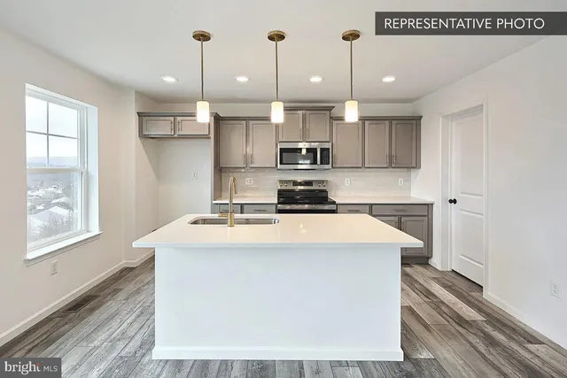 a kitchen with kitchen island a stove a sink and a refrigerator