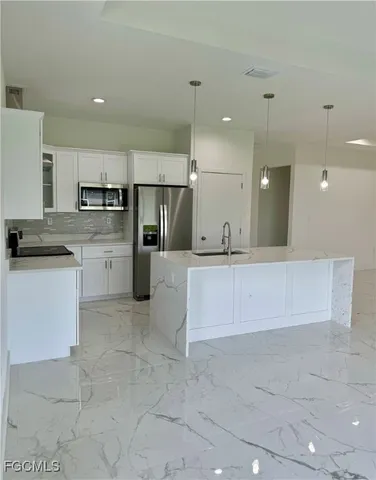 a kitchen with a sink a counter space and cabinets