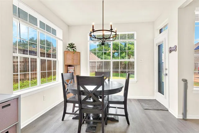 a view of a dining room with furniture large windows and wooden floor