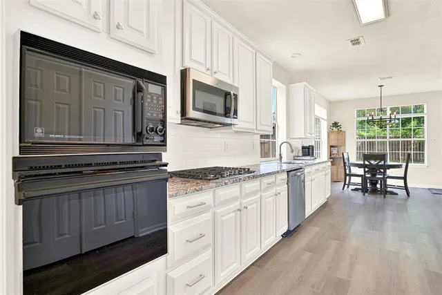 a kitchen with stainless steel appliances granite countertop a stove and cabinets
