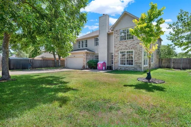 a front view of a house with a yard and tree