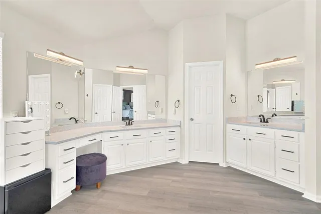 a spacious bathroom with a granite countertop double vanity sink and a mirror