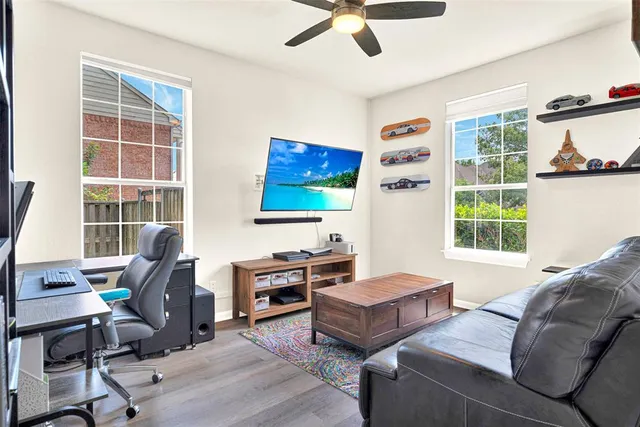 a living room with furniture a flat screen tv and a window