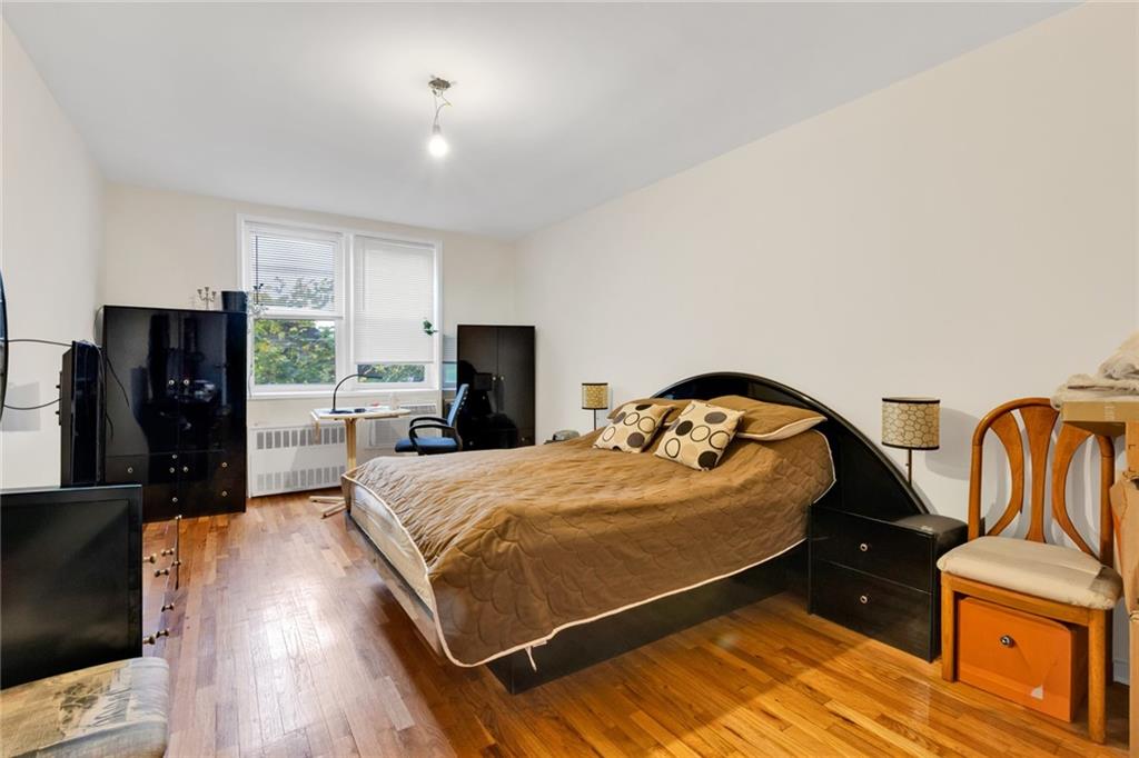 2155 82nd Street, Unit 3J Brooklyn, NY 11214 - Photo 3 of 15 a bedroom with a bed and wooden floor