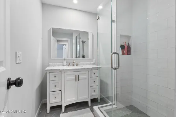 a bathroom with a double vanity sink a mirror a shower and a bathtub