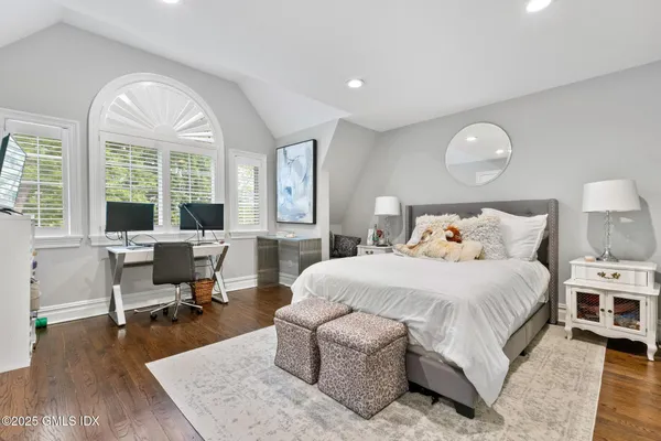 a bedroom with a bed and large windows