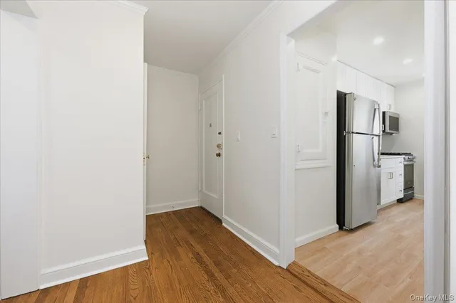 a view of a kitchen with wooden floor and a refrigerator