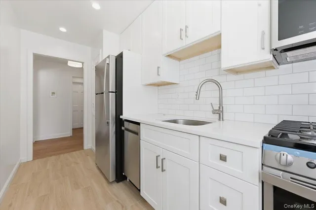 a kitchen with white cabinets and appliances
