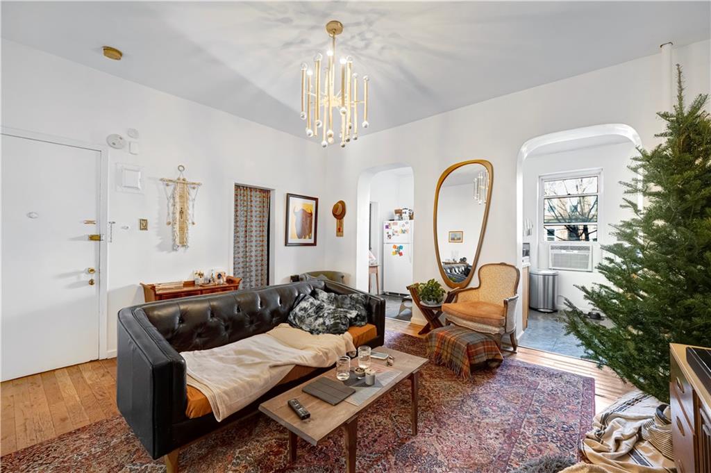 151 Kane Street Brooklyn, NY 11201 - Photo 2 of 14 a living room with furniture a chandelier and a fireplace