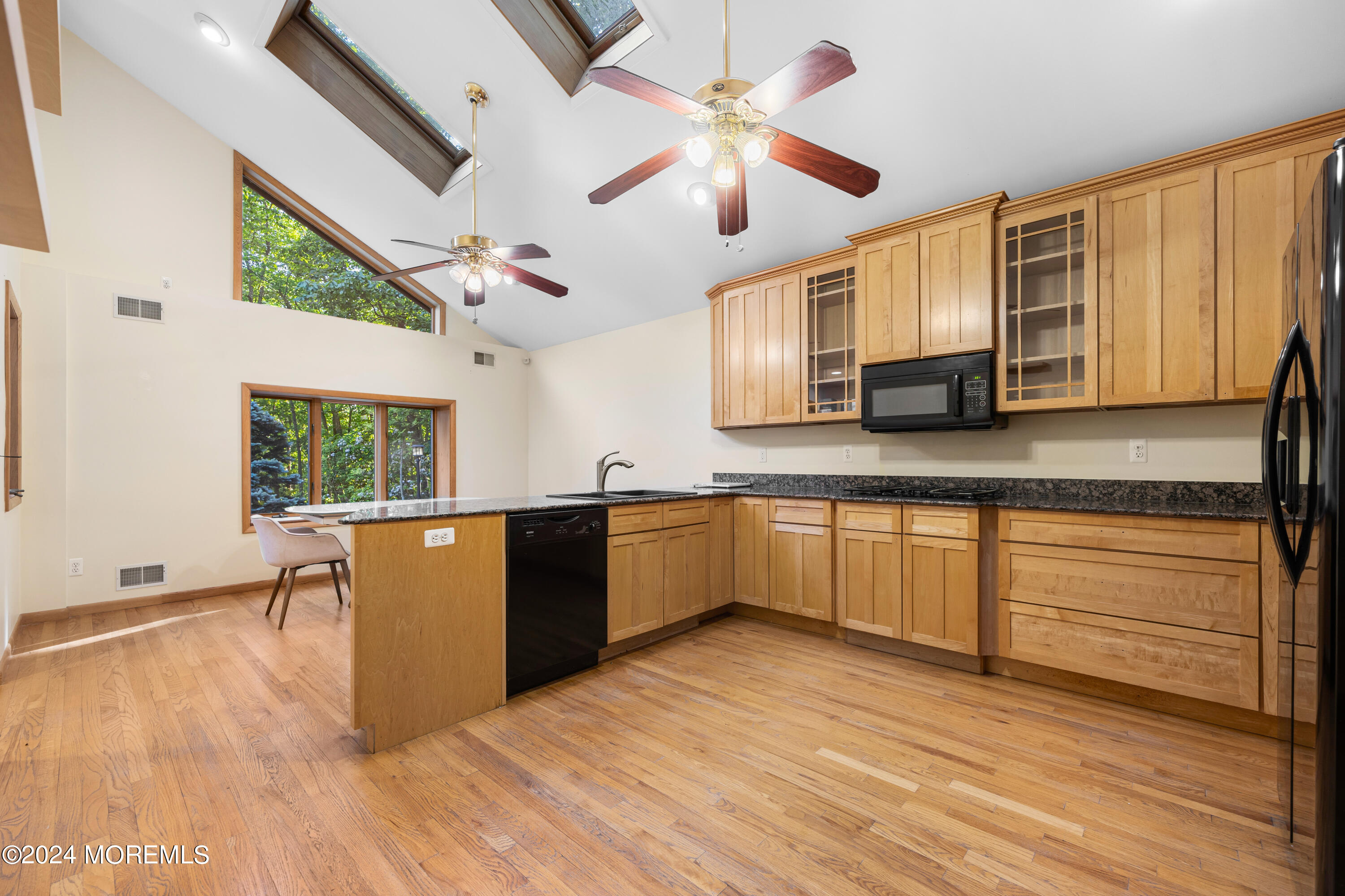 418 Stagecoach Road Millstone Township, NJ 08510 - Photo 10 of 43 a large kitchen with stainless steel appliances granite countertop a stove a sink dishwasher and microwave with wooden floor
