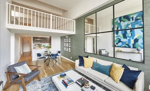 a living room with furniture a rug and a window