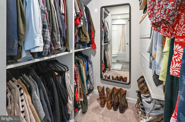 a view of walk in closet with clothes
