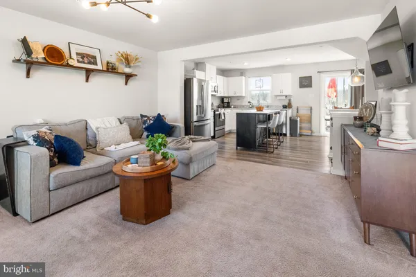 a living room with furniture and a dining table with kitchen view
