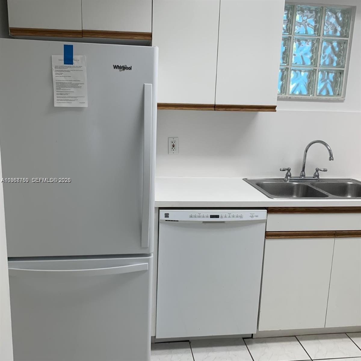 9156 Collins Avenue, Unit 204 Surfside, FL 33154 - Photo 5 of 17 a close view of a refrigerator in kitchen and cabinets